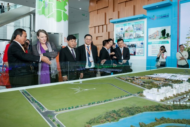越共中央委员、省委书记陈文南（左），省委副书记、省人民委员会主席陈青廉（左三）向玛丽•安•施鲁尔斯女士介绍平阳新市项目。