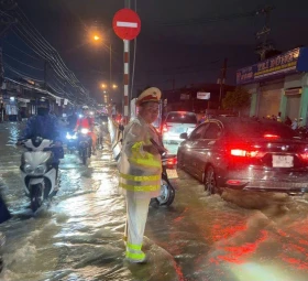 Cảnh sát giao thông hỗ trợ bà con di chuyển an toàn qua điểm ngập nước cục bộ sau cơn mưa lớn